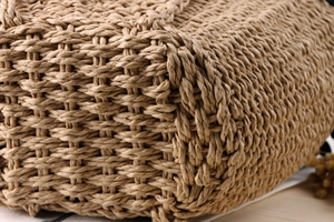 Close-up of the natural paper straw weaving texture on a rustic summer beach bag