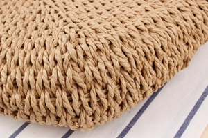 Macro detail of natural straw woven texture on a minimalist summer beach handbag