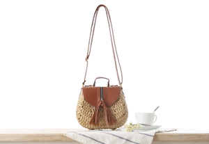 Dettaglio della borsa intrecciata in corda con frange in pelle marrone e zip in metallo
