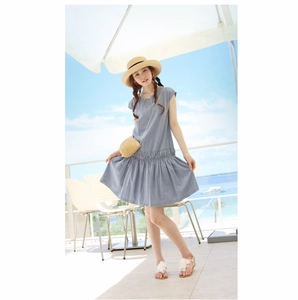 Robe d'été bleue sans manches plissée avec sac en paille tressée et chapeau sur une terrasse