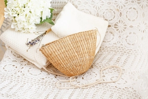 Vue détaillée du sac en paille tissé à la main sur une nappe en dentelle décorative