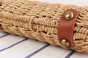 Close-up of woven paper rope texture with leather strap and metal rivet details