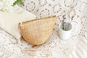 Détail d'un petit sac bandoulière en paille tressée main avec fermeture éclair