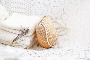 Vue détaillée du sac en paille tressé à la main avec bordure en corde blanche sur dentelle