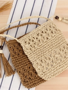 Handmade hollow woven beach bag with floral patterns and tassels in beige and dark brown