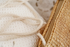 Détails de la texture en paille tressée, fermeture éclair et sac intérieur en maille