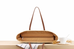 Detailed view of the striped woven beach bag showing inner lining and secure zipper pocket
