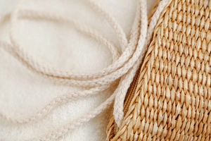 Détail de la texture d'un sac en paille fait main avec bandoulière tressée crème
