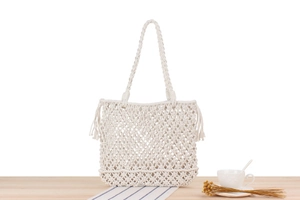 Close-up of handmade woven tote bag featuring cotton rope mesh and fringe detail