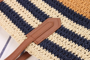 Detailed close-up of navy and beige woven stripes with premium brown leather strap attachment