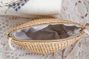 Détail du sac bandoulière en paille tisse avec doublure en tissu blanc et fermeture éclair