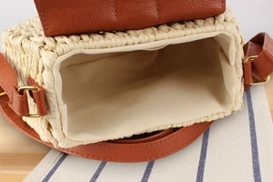 Dettaglio della borsa in corda di carta con fodera in twill e tracolla in pelle marrone