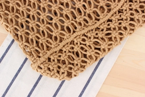 Detail of intricate macrame knotting and texture on the woven cotton shoulder bag