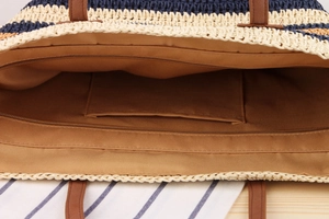 Detail view of striped woven tote bag interior with zipper pocket and brown lining