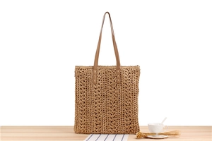 Detail of hand-woven paper rope tote with brown leather handles and geometric pattern