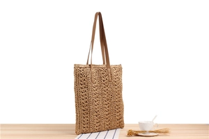 Detailed macro view of the intricate hollow weave pattern on this straw tote bag