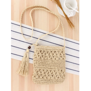 Handmade woven hollow straw crossbody bag in beige with decorative tassel detail