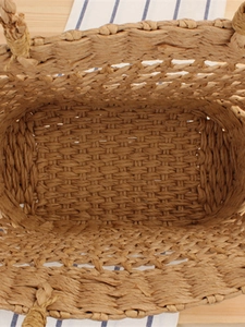 Overhead view of a handmade woven straw shoulder bag with durable paper rope texture
