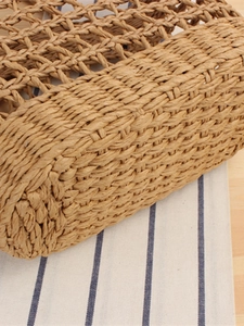 Handwoven straw tote bag with intricate knit texture and minimalist hollow pattern design