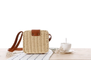Nahaufnahme einer gewebten Umhängetasche aus Papier auf einem Tisch mit Kaffeetasse