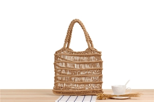 Detailed close-up of handmade woven cotton rope mesh tote bag on a wooden table