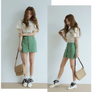 Detail showing handwoven paper rope crossbody bag paired with beige crochet vest and green skirt
