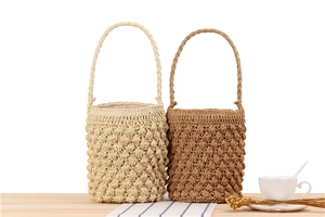 Detailed bobble stitch texture on handcrafted paper rope woven bucket bags for summer