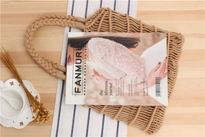 Detail of hand-woven cotton rope mesh shoulder bag with braided handles and natural texture