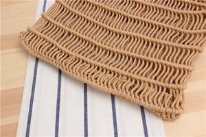 Macro detail of hand-woven cotton rope mesh bag with dense wavy crochet texture