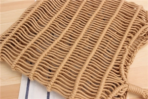 Close-up of handmade cotton rope mesh bag with intricate knot weaving on wooden background