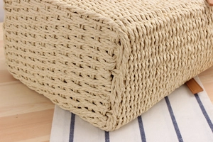 Close-up of beige woven beach bag with premium leather straps on a wooden table