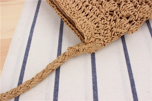 Macro detail of hand-woven paper rope bucket bag with braided shoulder strap