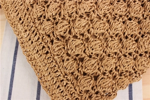 Macro detail of hand-woven paper rope bucket bag with textured bobble stitch and fabric lining