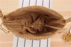 Top view of handwoven cylinder straw bag showing fabric lining and secure drawstring closure