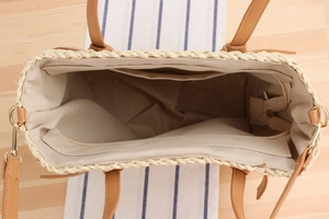 Interior view of straw woven tote bag featuring zip pocket and leather shoulder straps