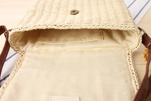 Close-up of handmade woven straw bag interior showing magnetic buckle and inner pocket