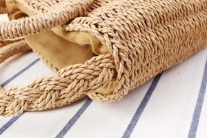 Close-up of hand-woven paper rope bag with reinforced handle and yellow lining detail