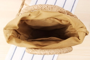 Detailed top view of a woven straw bag showing the durable beige lining and internal pocket