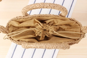 Detailed view of paper rope woven bag with drawstring fabric lining on wooden table