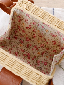 Minimalistische gewebte Strohtasche mit Blumenfutter und braunem Lederriemen