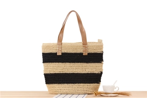 Detail view of woven paper rope tote bag featuring striped pattern and leather handles
