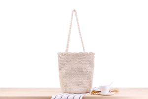 Detail of beige crochet cotton rope tote bag showing intricate hand-woven texture and wavy edge