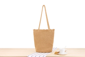 Close-up of handmade woven cotton shoulder bag with natural rustic texture for summer beach