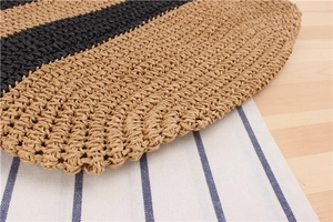 Close-up of the natural woven fiber texture with black contrast stripes on a wooden table