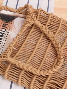 Handmade khaki cotton rope woven shoulder bag with bohemian mesh design on wooden table