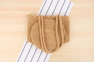 Detail of hand-woven cotton rope tote bag with intricate petal edge and natural texture
