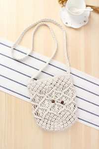 Detail of bohemian handmade macrame bag with wooden bead drawstring on wooden surface