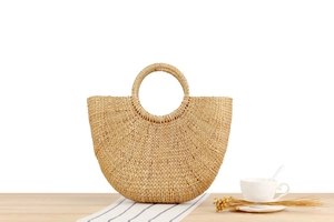 Handcrafted straw handbag on wooden table with nautical decor for summer beach outings