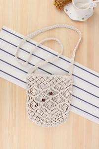 Detail of macrame shoulder bag with cotton weave patterns and wooden bead closure