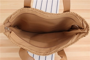 Top view of striped straw tote bag showing zipper closure and soft inner fabric lining